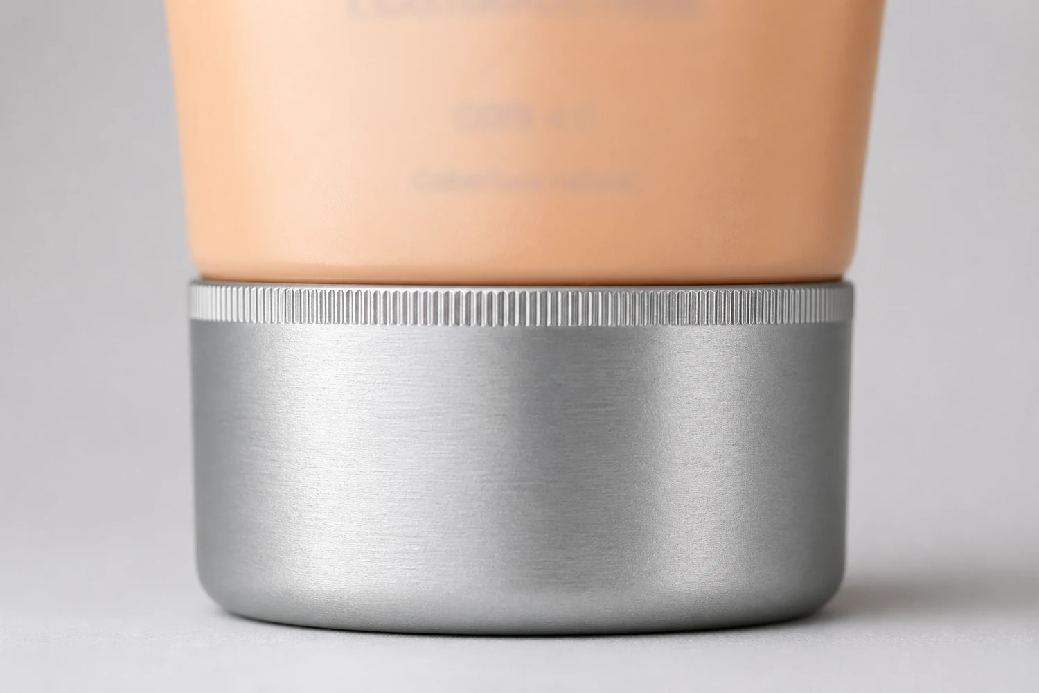 Close da base prateada larga em que o tubo do BB cream se apoia.