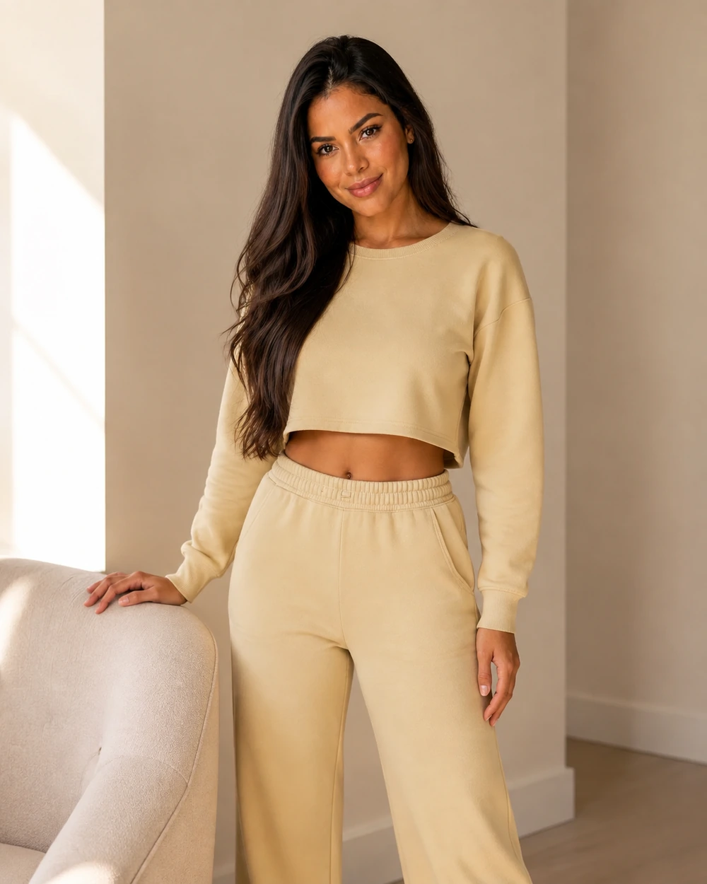 Maya com conjunto de moletom feminino cropped e calça em um ambiente residencial.