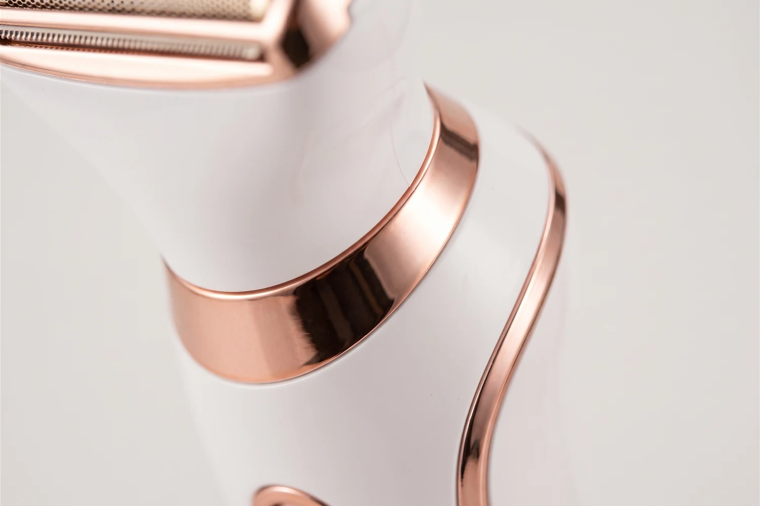 Close do anel e do filete rosé dourado no corpo branco do depilador FINKÈ.